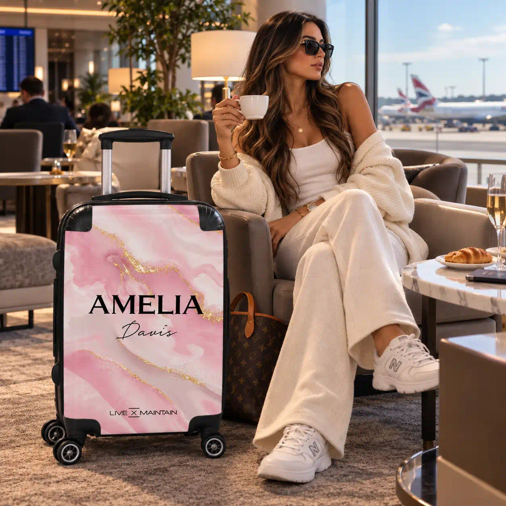 Personalised hardshell cabin suitcase featuring a pink and gold liquid marble design with the custom name text Amelia Davis.